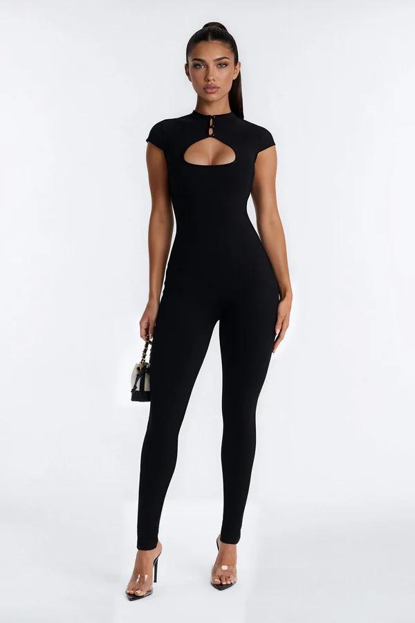 Model posing in a tight black jumpsuit with a front keyhole cutout and high neck, showcasing chic evening party wear fashion.