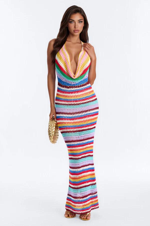 Model wears a colorful striped crochet maxi dress with a deep halter neck, promoting the new vibrant summer resort wear collection.