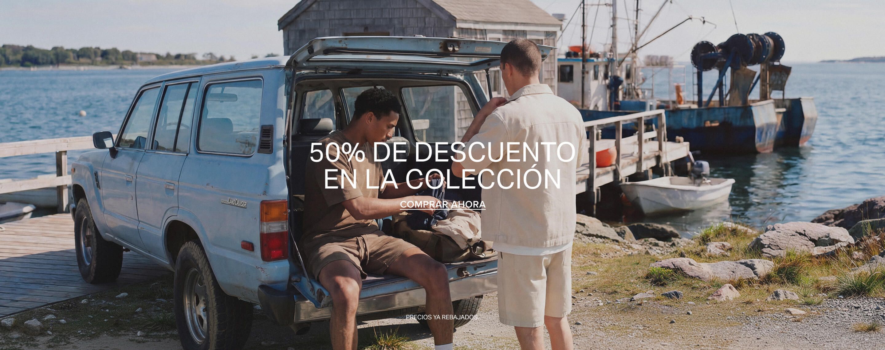 Dos hombres con moda casual de verano junto a un coche, promocionando un 50% de descuento en la colección de ropa masculina. ¡Compra ya!