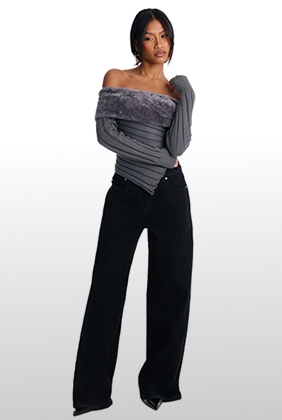 Woman modeling a trendy charcoal gray faux-fur off-the-shoulder knit top paired with black wide-leg jeans for a chic winter collection outfit.