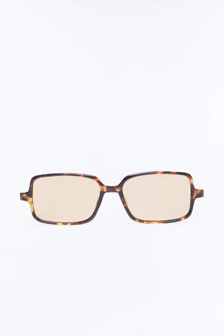 Modernas gafas de sol rectangulares con montura de carey y lentes marrones claras, destacadas y centradas sobre un fondo blanco puro, vistas de frente.