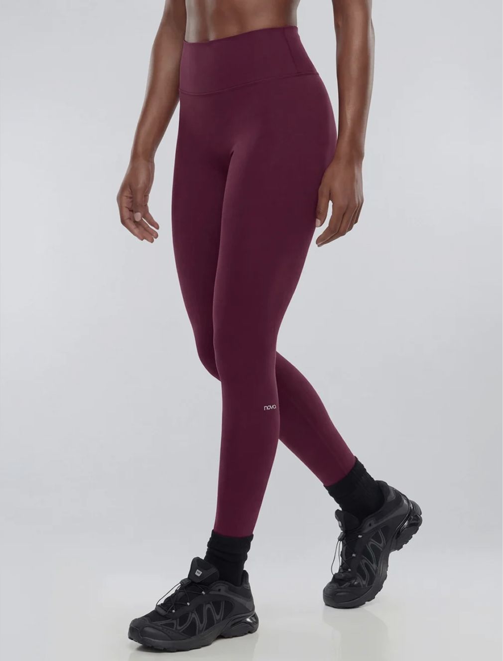 High-waisted burgundy athletic leggings for women with black running shoes.