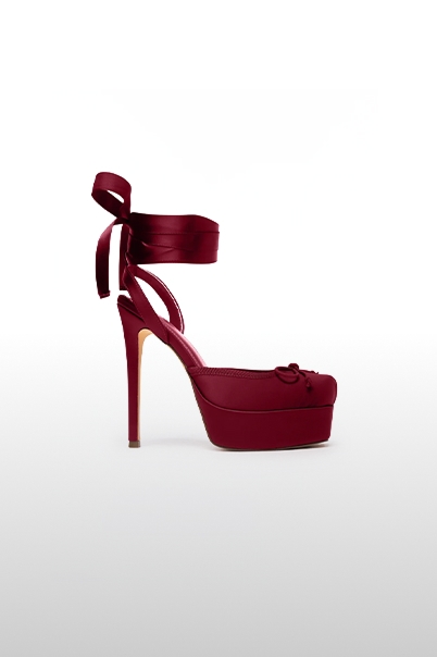 Burgundy satin platform heels with ankle-wrap ribbons and stiletto heel, shown in side profile for the new women's shoe collection.