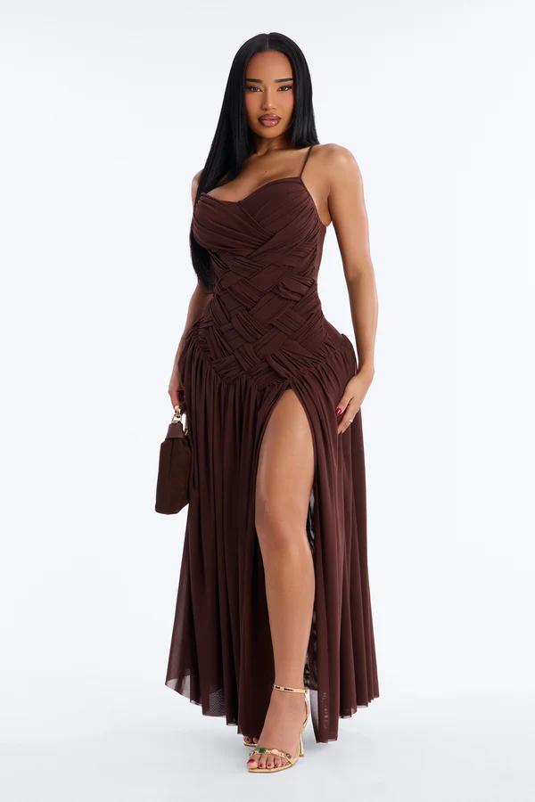 Woman in a chocolate brown maxi dress with woven bodice and high slit, modeling elegant formal evening wear on a white background.