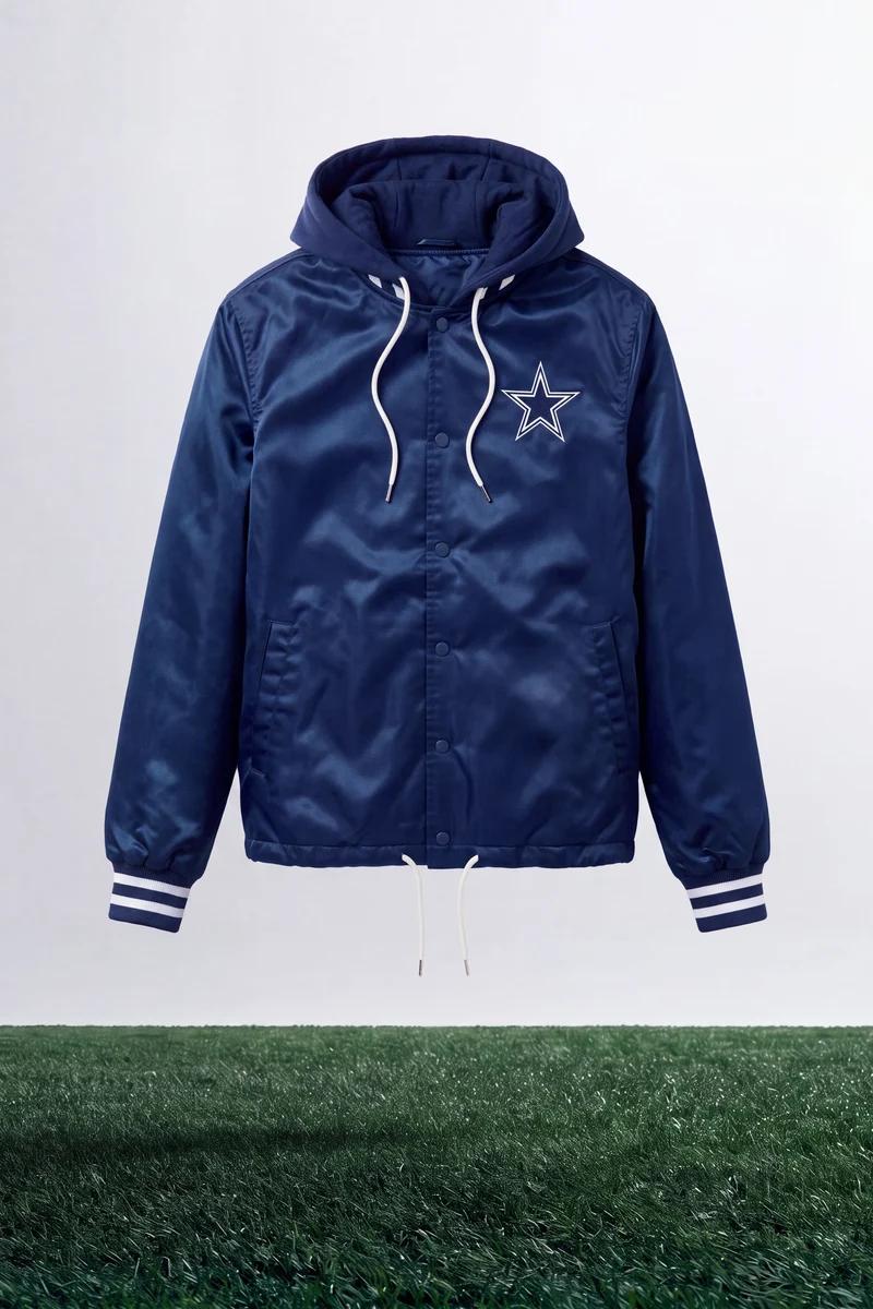 Navy Dallas Cowboys hooded jacket with white star logo, drawstrings, and cuff stripes. This stylish fan gear outerwear floats above green turf.