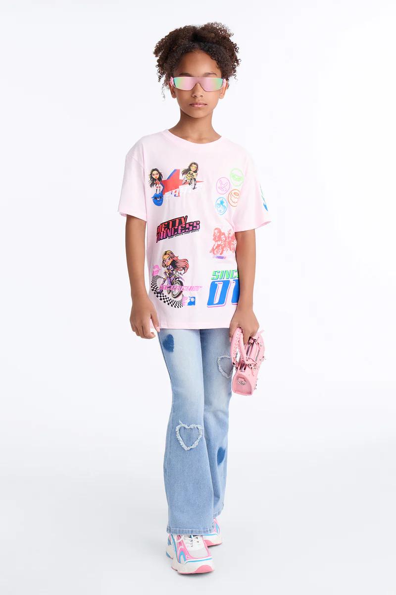 Niña con camiseta rosa estampada, jeans acampanados de corazón, zapatillas chunky y gafas de sol rosadas con bolso.
