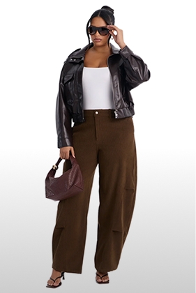 Moda de otoño elegante con modelo en chaqueta de cuero marrón, top blanco, pantalones de pernera ancha y bolso de hombro a juego.