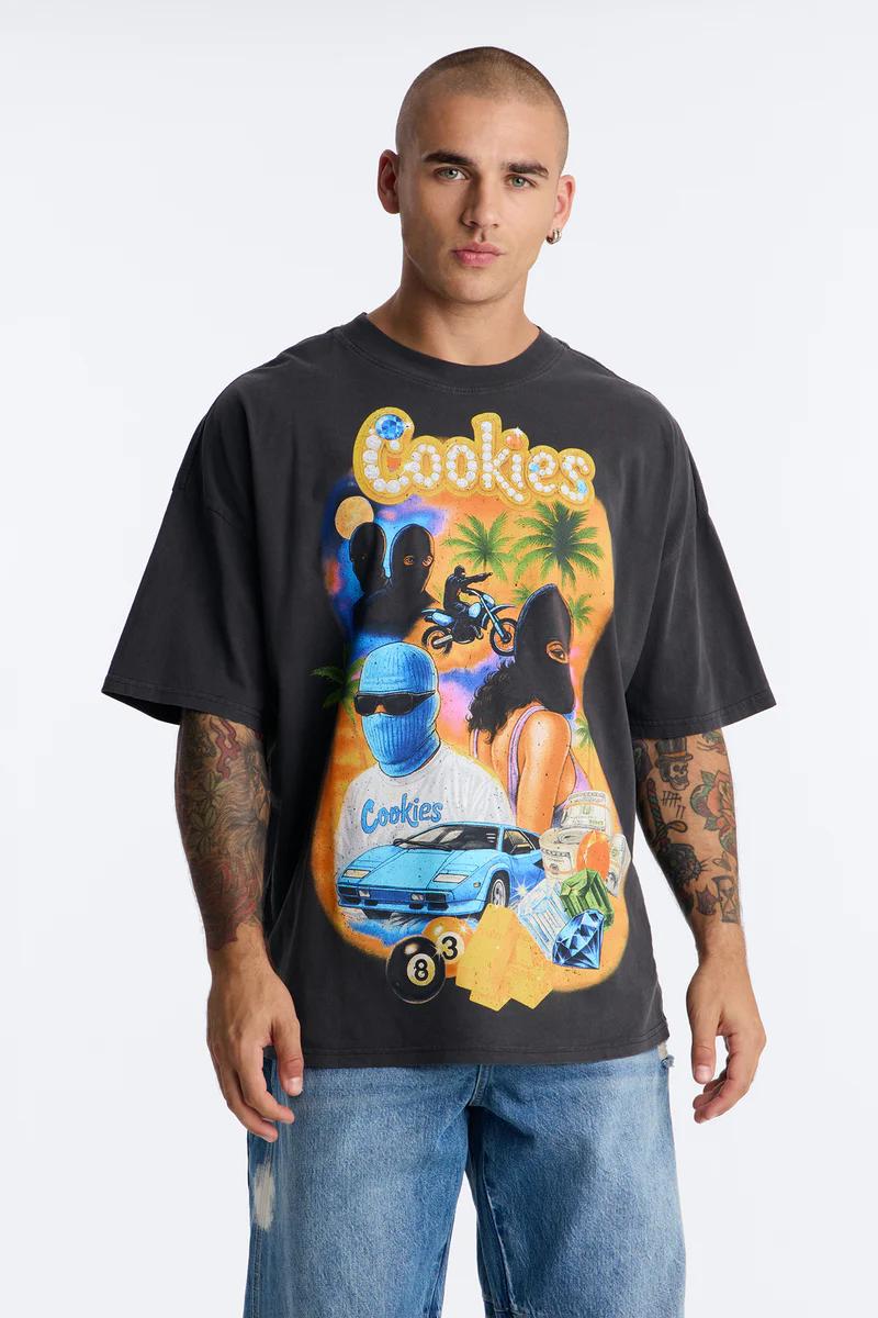 Man wearing a dark grey Cookies graphic t-shirt featuring a vibrant street culture design with cars, money, and characters in masks. Shop Cookies streetwear.