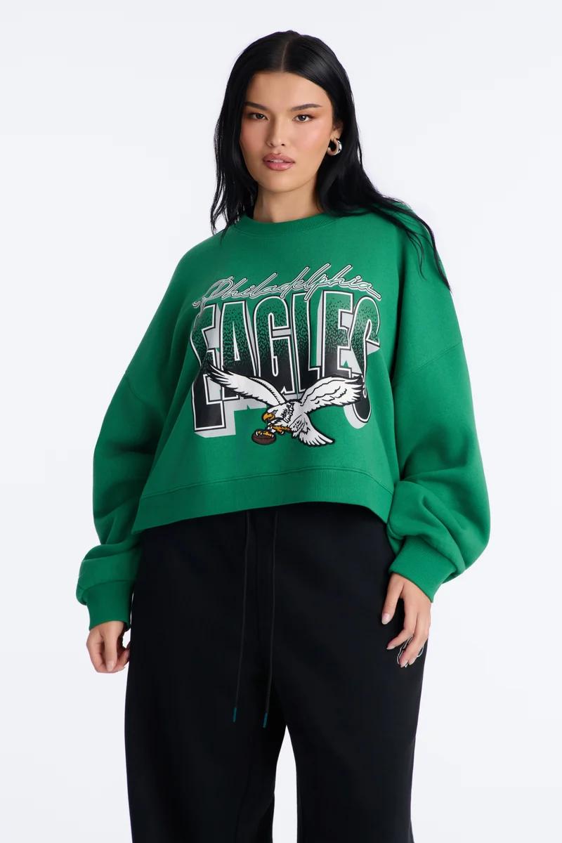 Woman in a green cropped Philadelphia Eagles crewneck sweatshirt.