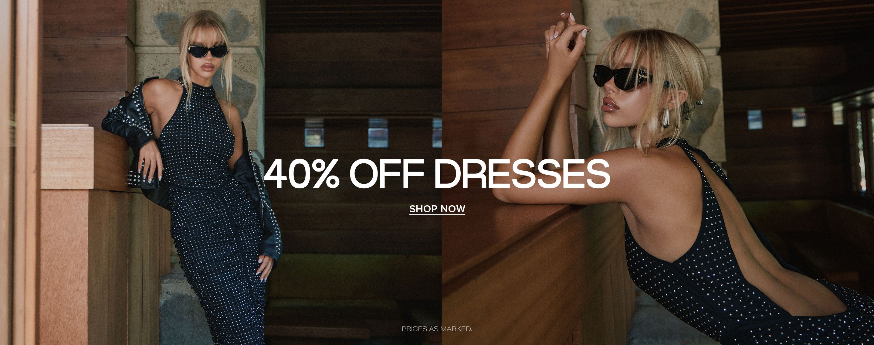 Blonde woman in a studded black halter dress and leather jacket posing near wood walls for a 40% off dresses fashion sale.