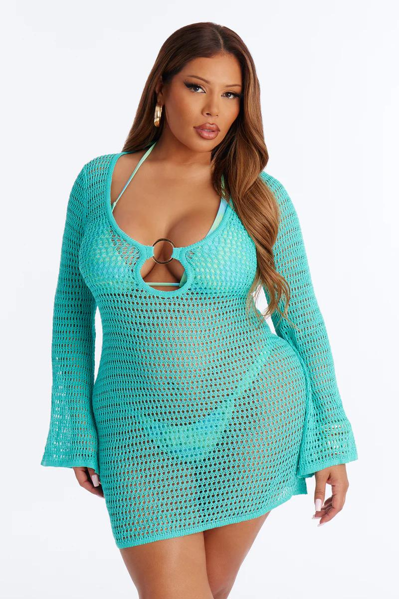 Mujer talla grande con vestido pareo de ganchillo turquesa, manga larga y abertura con aro. Ideal playa y resort.