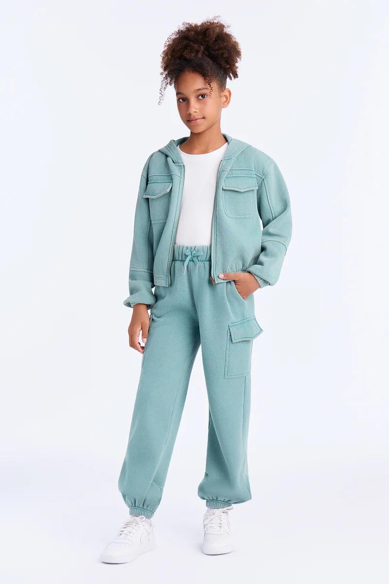 Girl in a mint green cargo hooded jacket and matching jogger pants.