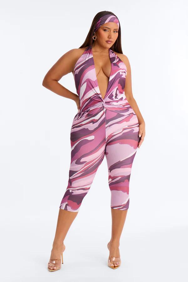 Modelo de talla grande luciendo mono halter estampado abstracto en rosa y morado con pañuelo. Explora nuestra nueva colección.