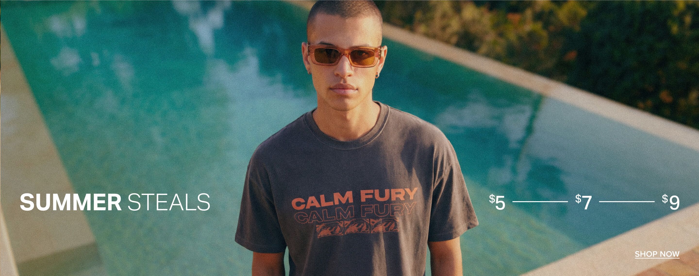 Man in brown sunglasses and dark gray graphic tee by a turquoise pool. Promotes "SUMMER STEALS" on men's fashion from $5-$9.