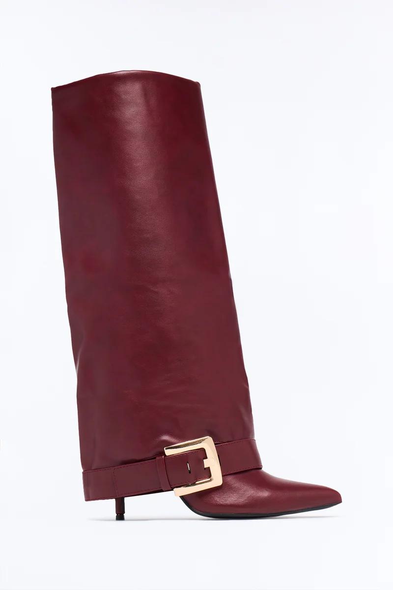 Burgundy leather fold-over knee-high boot with pointed toe, kitten heel, and gold buckle.