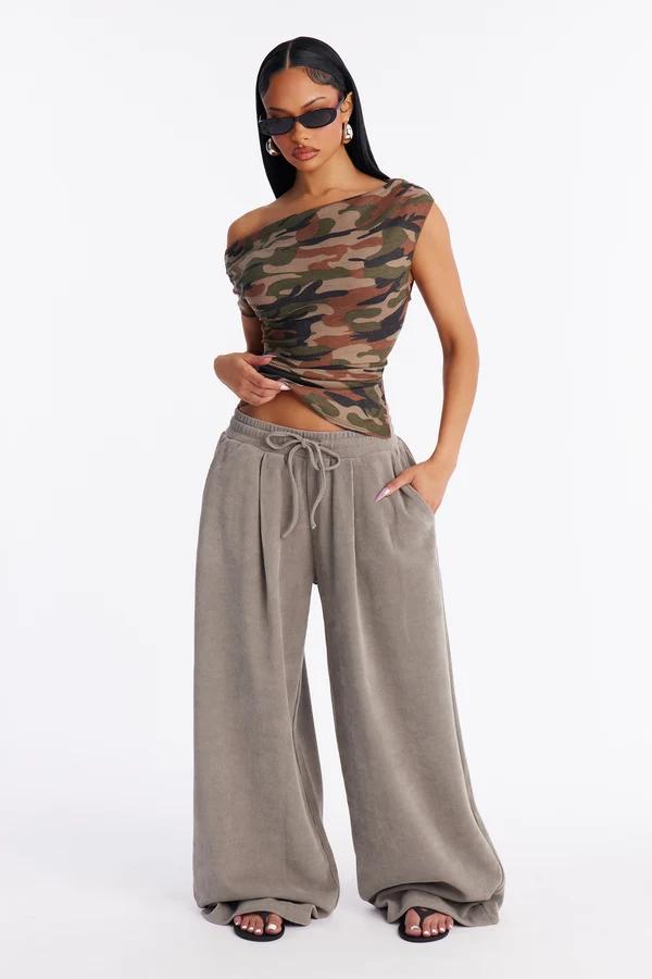 Modelo posa con una chaqueta cortavientos corta beige y negra y pantalones de chándal anchos de una nueva colección de moda urbana.