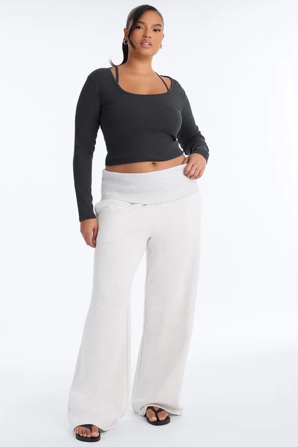 Plus size model wears a black long-sleeve crop top and heather gray wide-leg sweatpants from the new cozy athleisure loungewear collection.