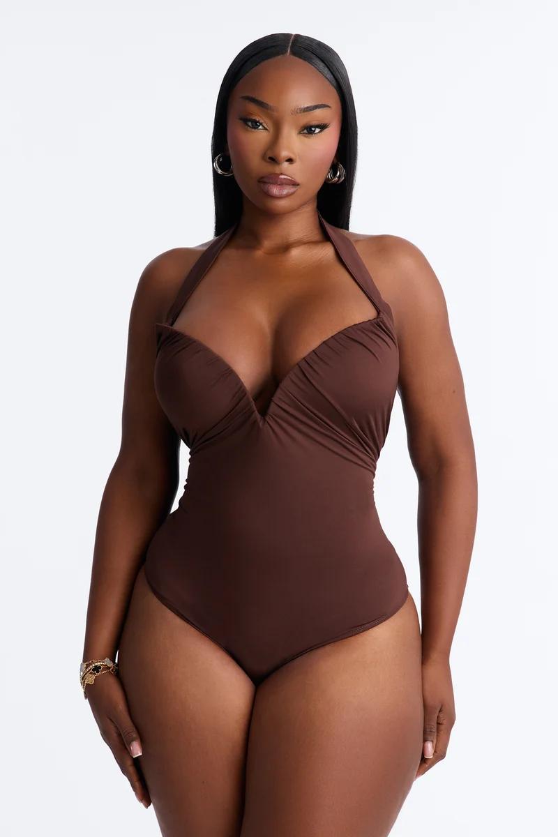 Woman wearing a brown halter neck bodysuit. 