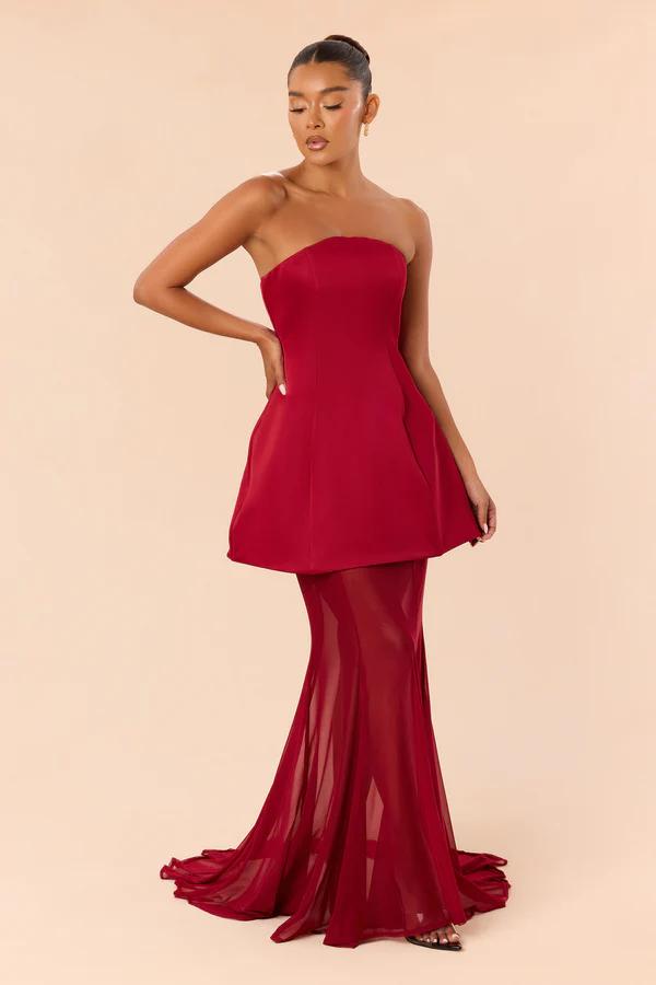 Elegant strapless red evening gown featuring a structured mini overlay and sheer flared skirt, perfect for formal prom or holiday party wear.