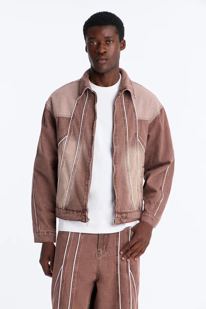 Man in stylish brown faded denim jacket and matching pants with white stripes, showcasing modern men's fashion and new collection.