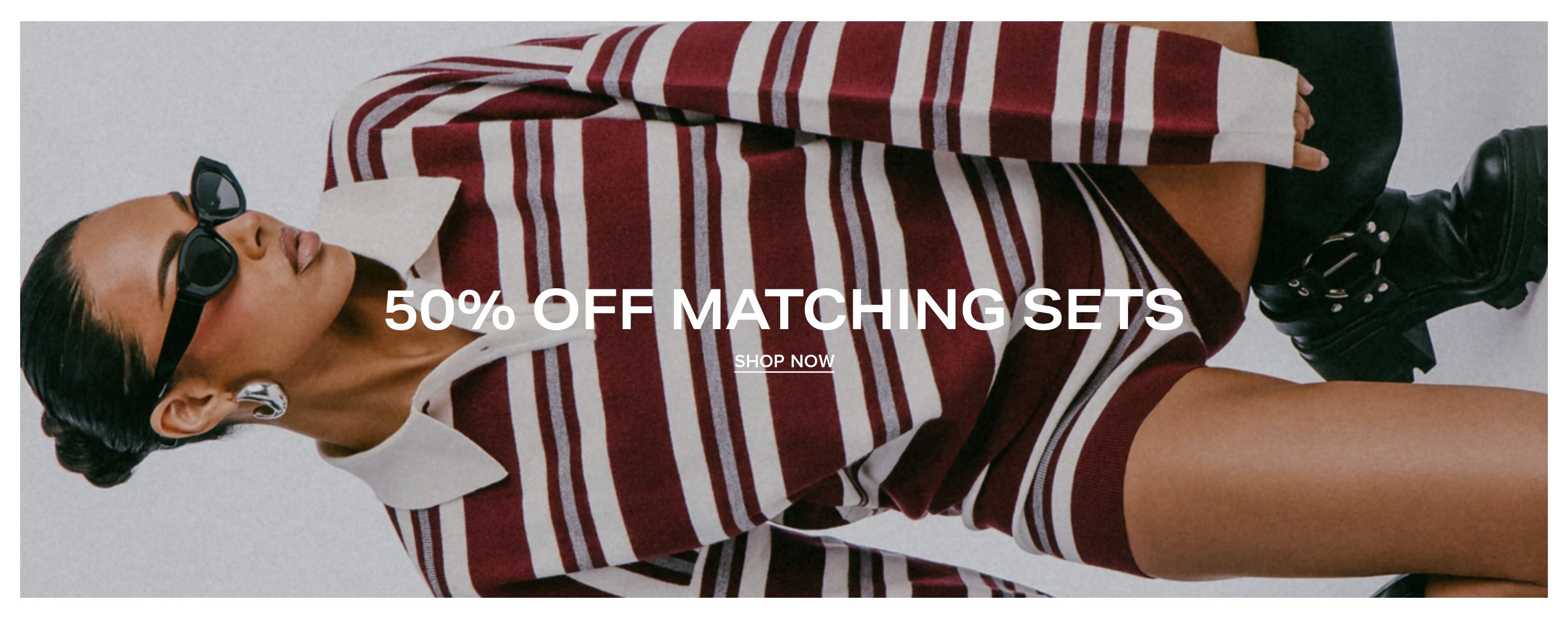 Woman wearing a striped burgundy and cream knit polo matching set, promoting a 50% off sale on matching sets with a shop now action button.