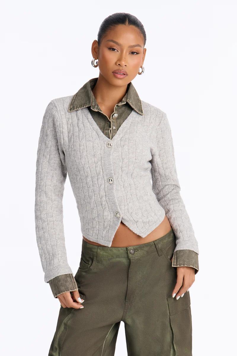 Model in grey cable-knit cardigan layered over green collared shirt and olive cargo pants.