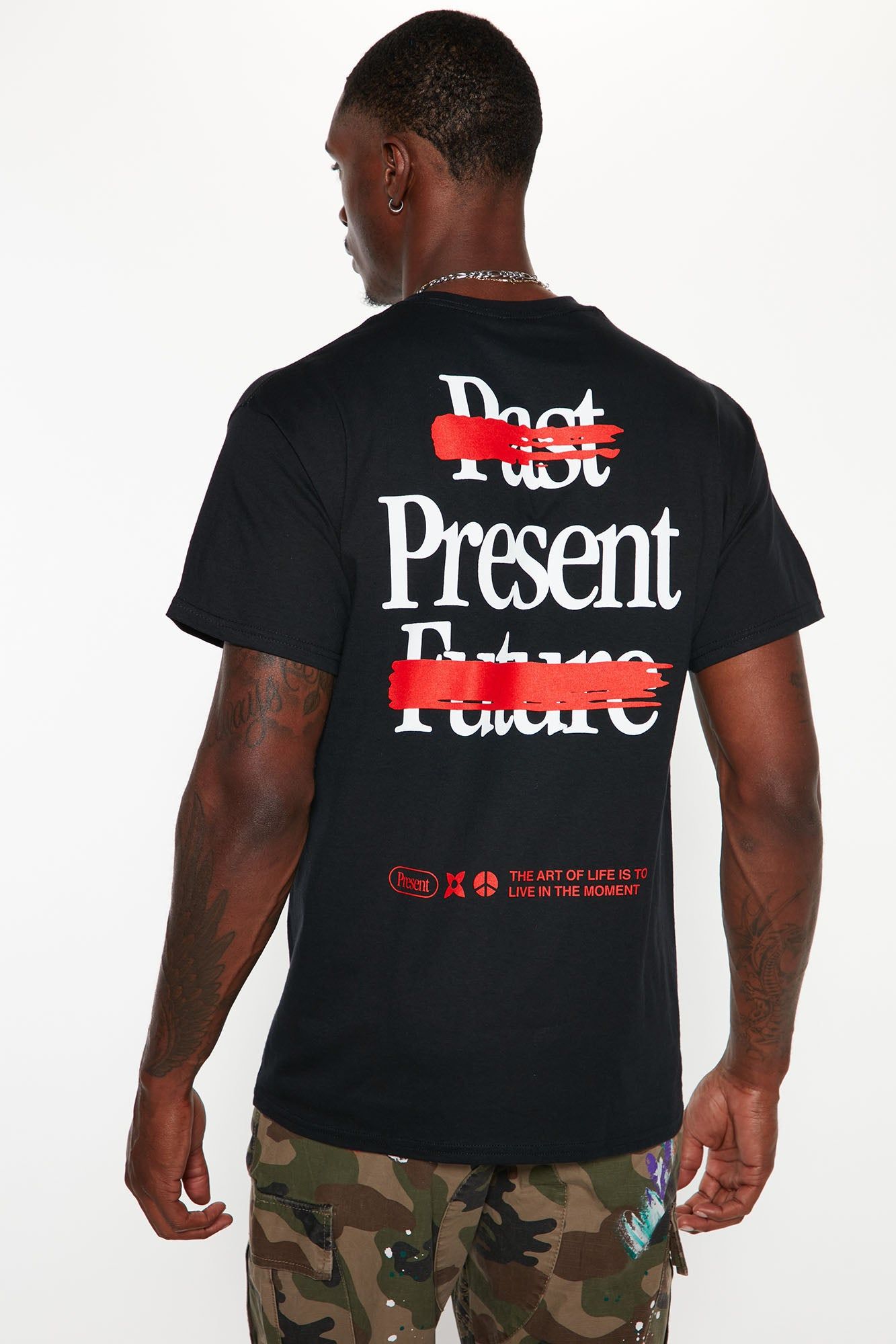 Black graphic t-shirt with "Past Present Future" text on back, "Past" & "Future" crossed in red, highlighting "Present". Promoting "Live in the Moment" men's casual wear.