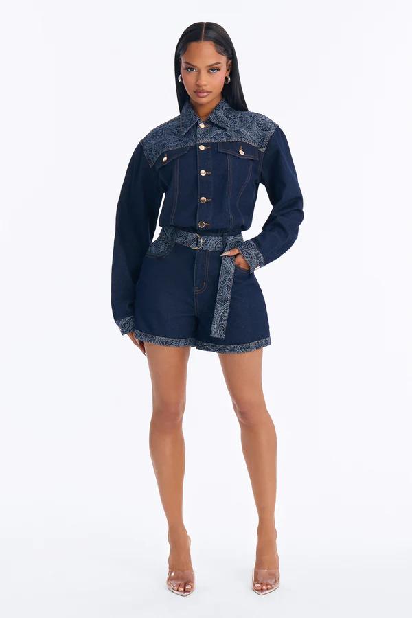 Woman in dark wash denim jacket and matching shorts with paisley print details, gold buttons, and clear heels. Shop the new denim set!