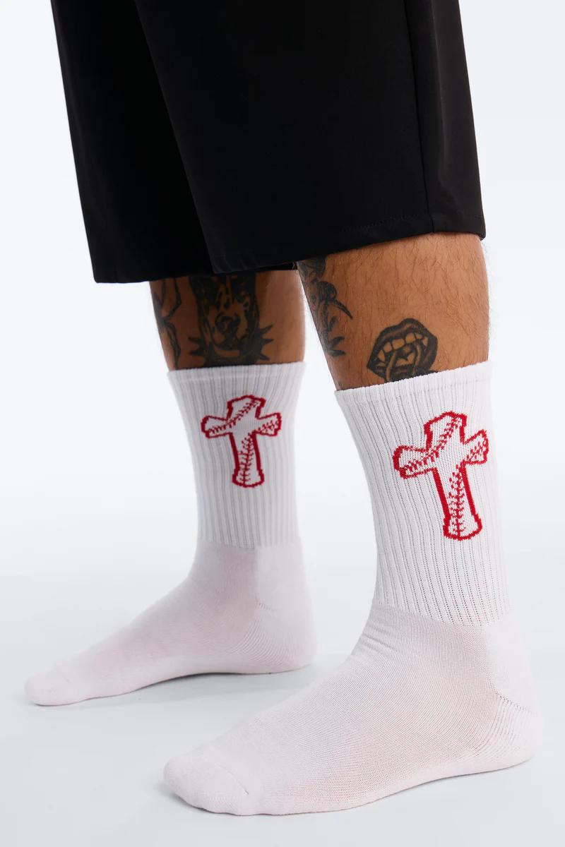 White crew socks featuring a vibrant red baseball cross design, paired with black shorts. Perfect for stylish streetwear accessories.
