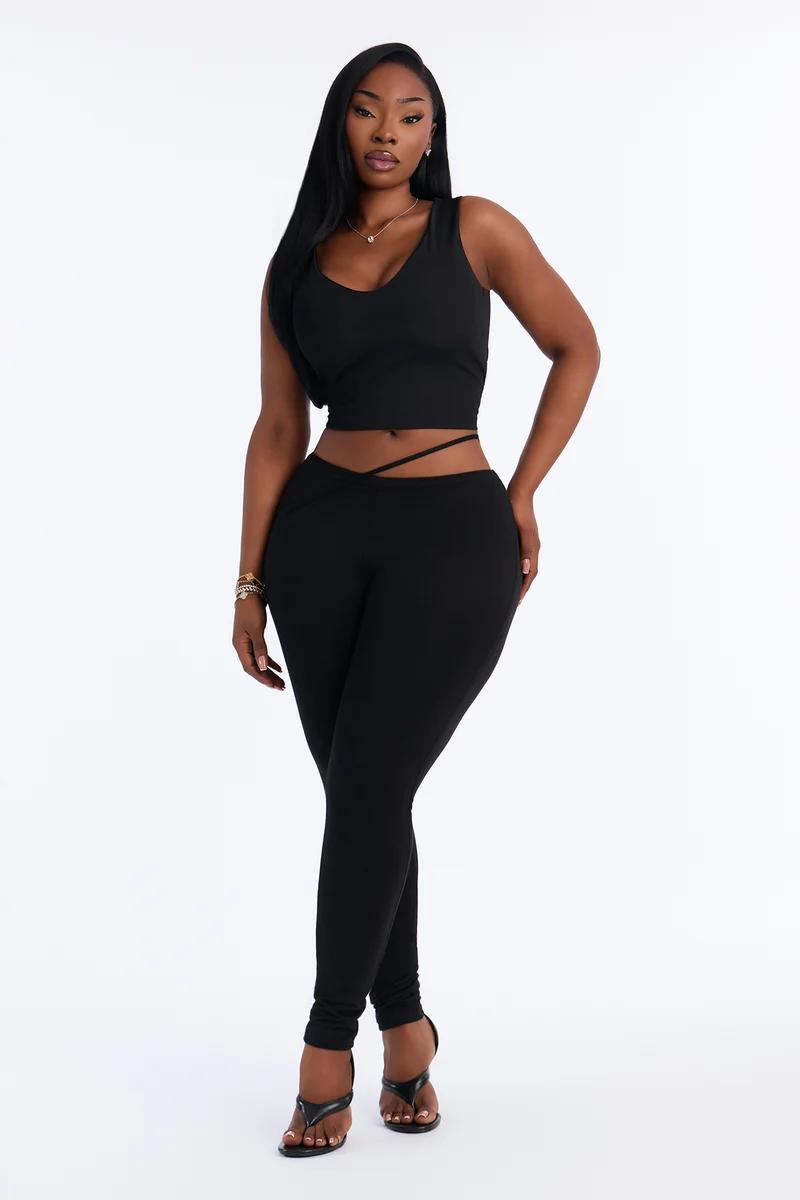Black two-piece set featuring a sleeveless crop top and strappy waist leggings.
