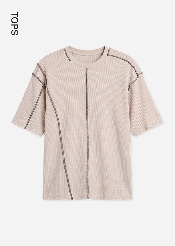 Beige waffle-knit short sleeve t-shirt featuring decorative exposed grey stitching, showcased for the new casual tops fashion collection.