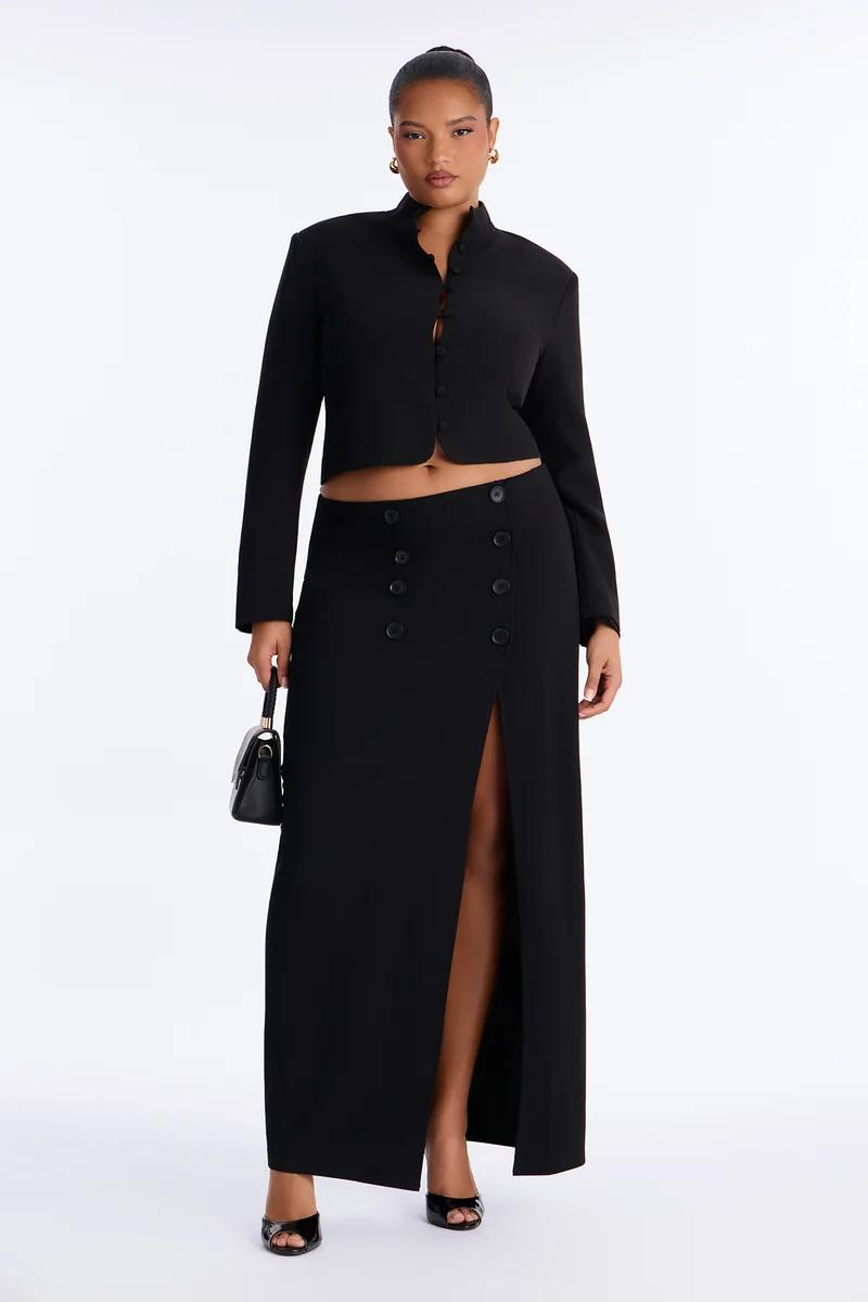 Model in a stylish black two-piece set featuring a cropped blazer jacket and high-waisted slit maxi skirt.