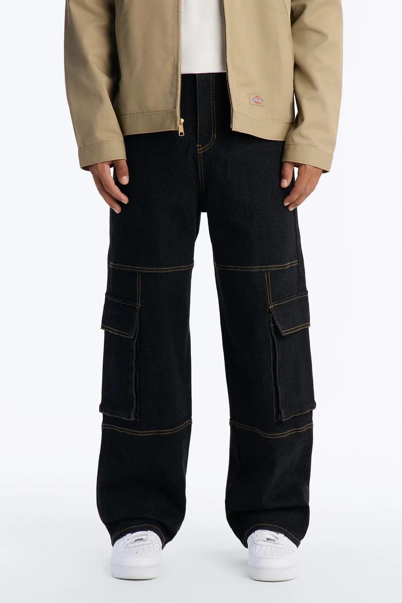 Stylish outfit featuring a tan jacket, white tee, and black cargo denim jeans with contrast gold stitching, finished with white sneakers. Explore new arrivals.