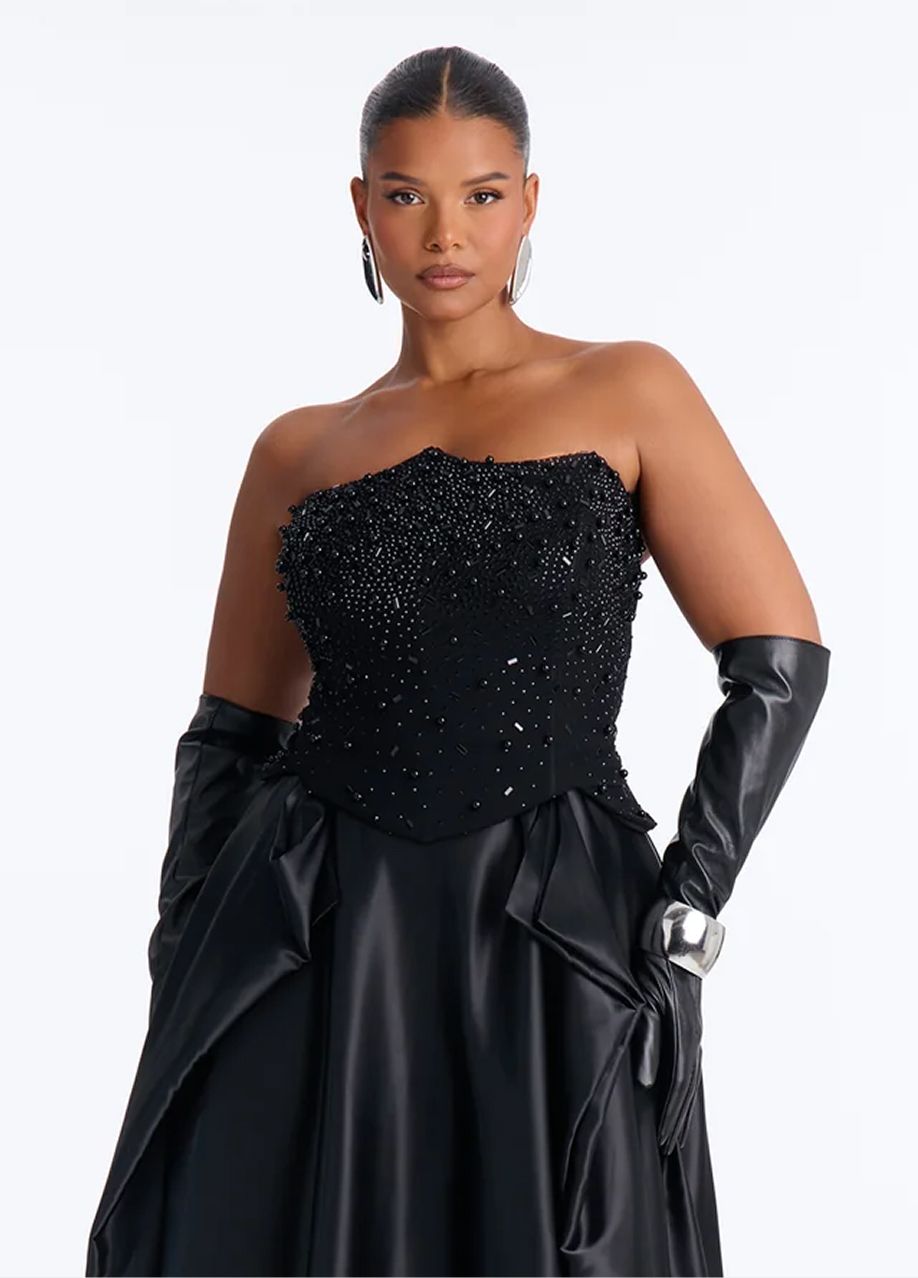 Elegant black strapless evening gown featuring a beaded bodice, satin skirt, and long leather gloves for a luxury formal wear collection.