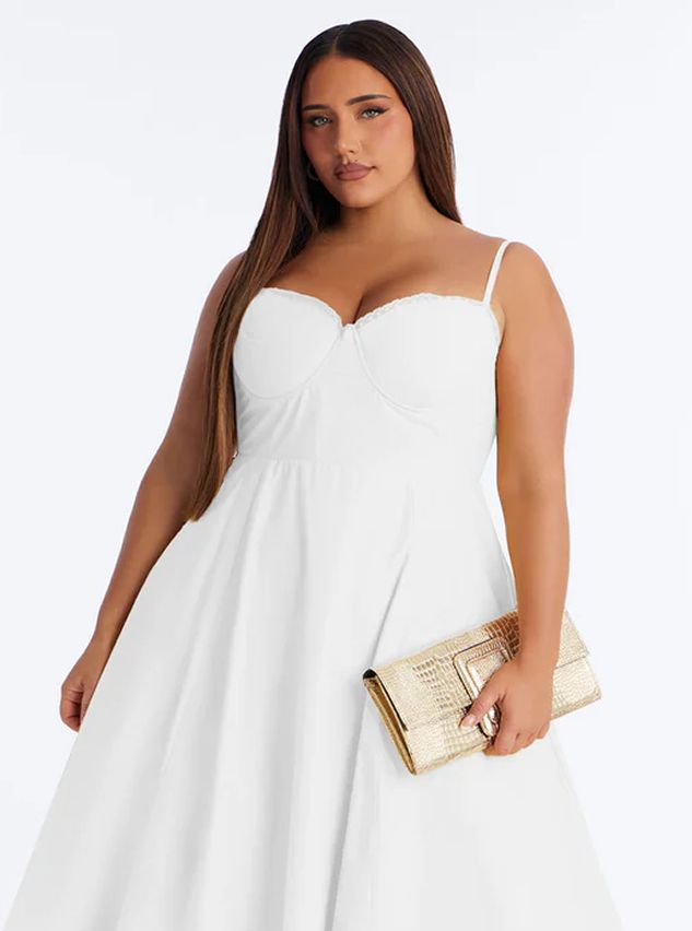 Woman in elegant white plus size bustier dress with thin straps, holding a golden crocodile-embossed clutch. Perfect for special occasions.