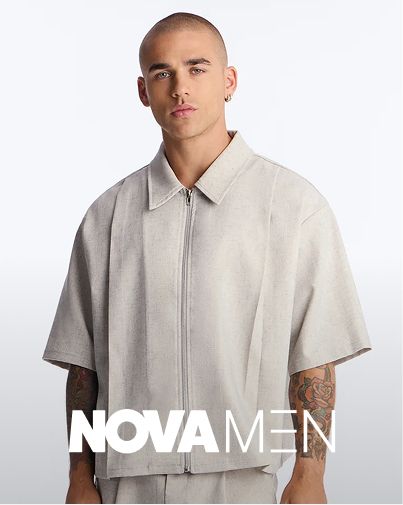 Man models Nova Men's light grey textured, oversized zip-up collared shirt on white background. Modern fashion for a fresh collection.