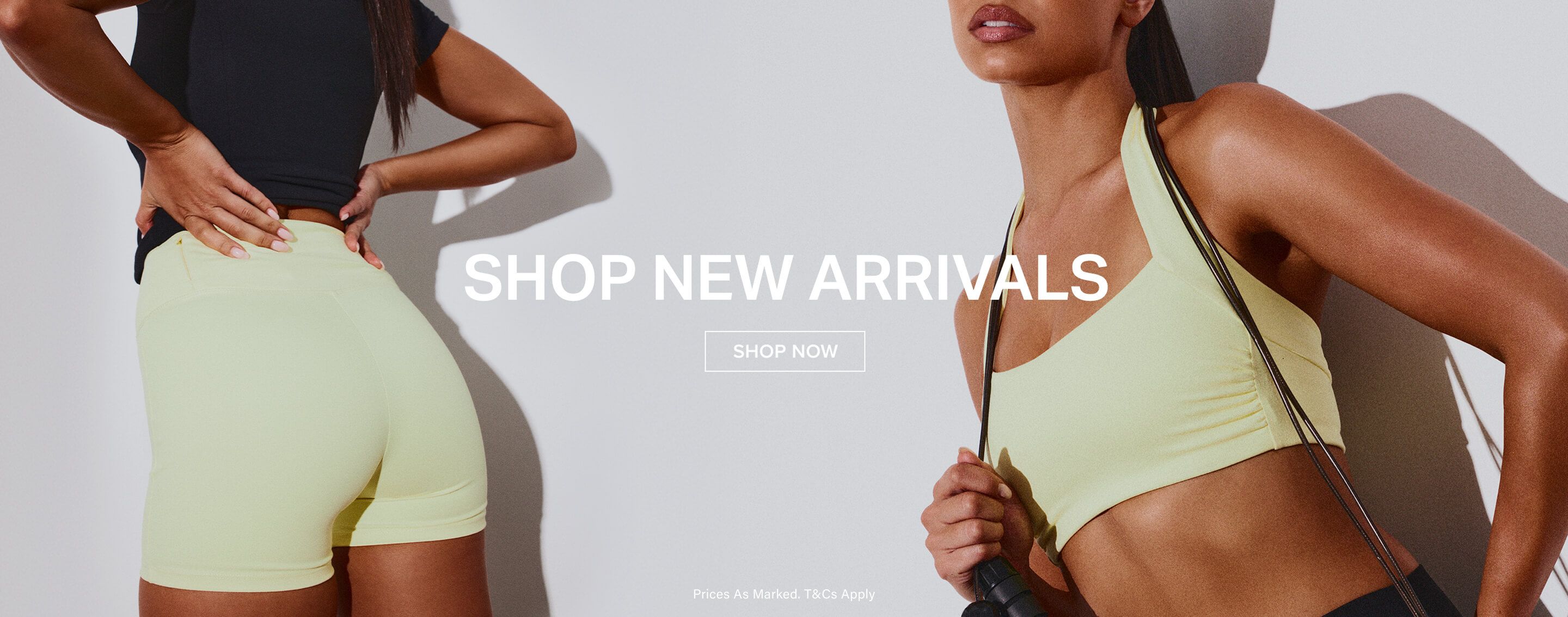 Woman in pale yellow sports bra and black leggings holding a jump rope, promoting new activewear arrivals. Shop now for workout clothes.