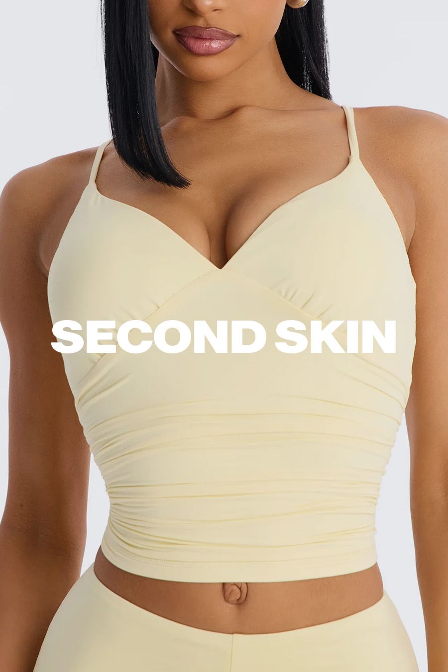 Woman in a buttery yellow ruched crop top and matching seamless leggings, showcasing the comfortable "Second Skin" activewear collection.