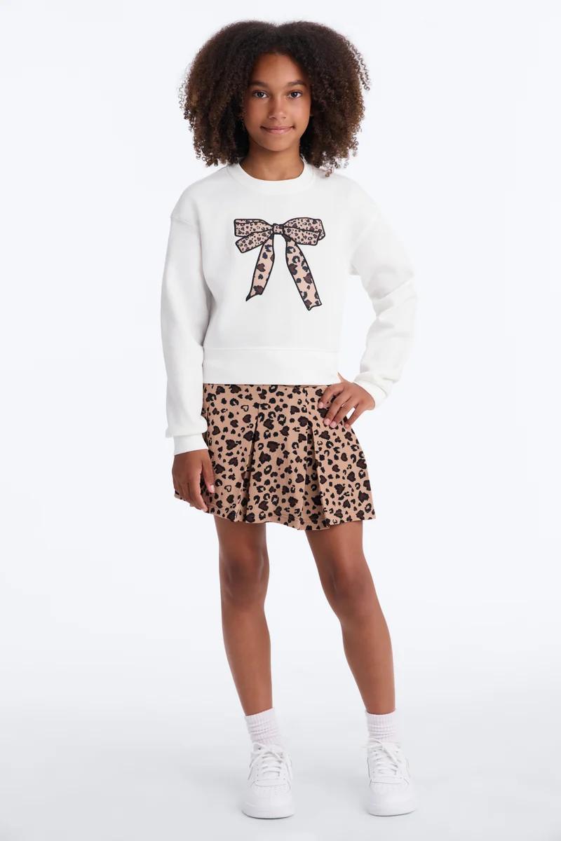Girl in black/grey striped rugby polo & matching mini skirt, prominent white collar/cuffs, black platform sneakers.