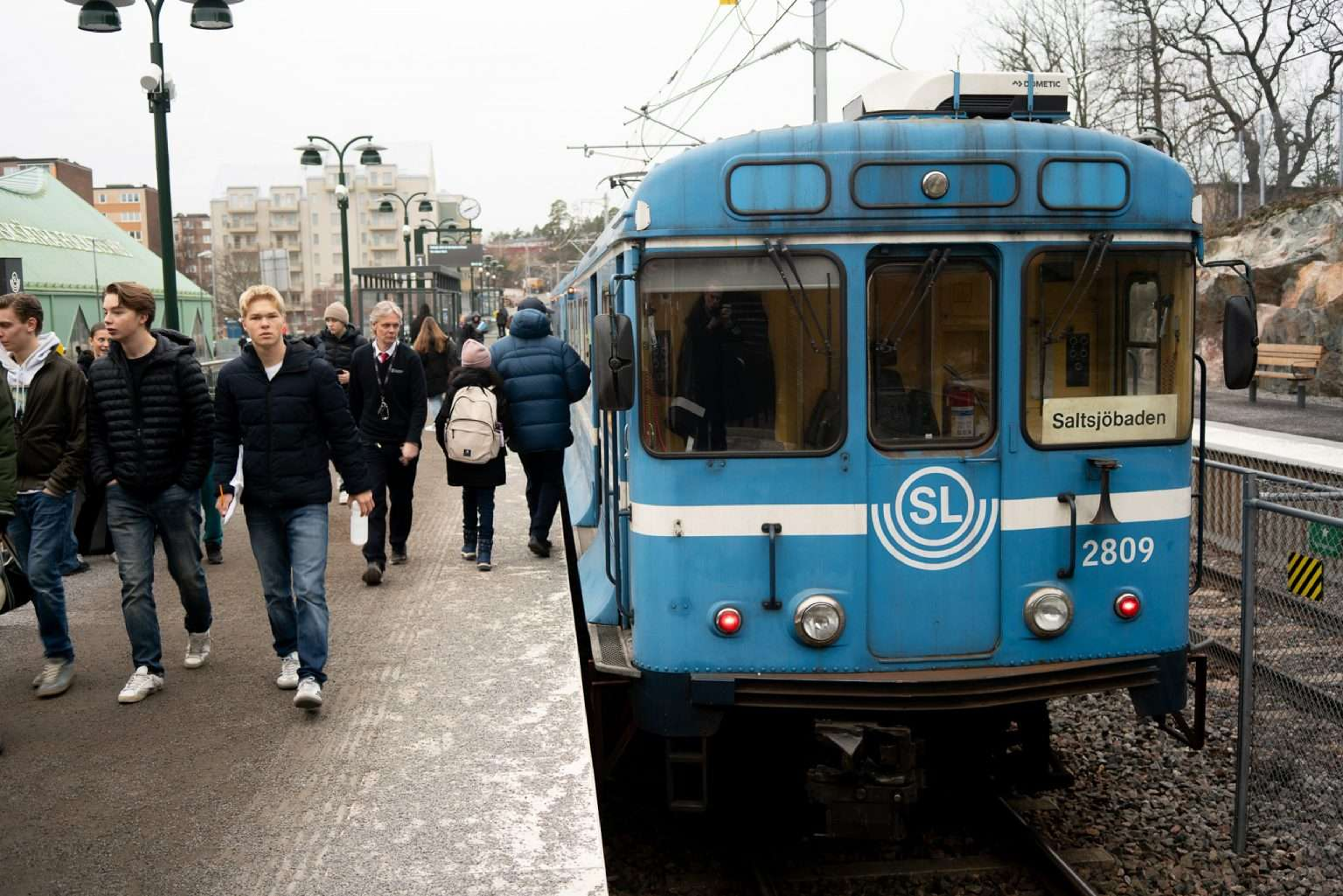 En bild på Saltsjöbanan vid Fisksätra station med människor på perrongen
