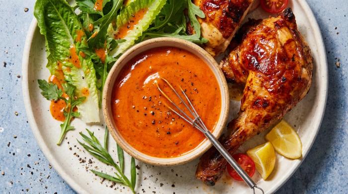 A jar of creamy French dressing next to a leafy green salad.