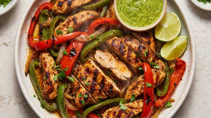 A colorful spread of chicken fajitas with tortillas and assorted toppings.