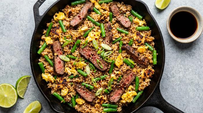 Finished steak fried rice in a ceramic serving bowl.