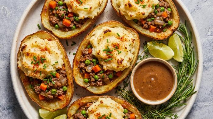 Baked Shepherd's pie potato skins with crispy mashed potato tops on a plate