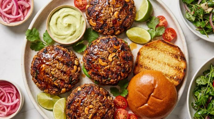 A tall veggie burger with melted cheese, lettuce, and tomato on a toasted bun.