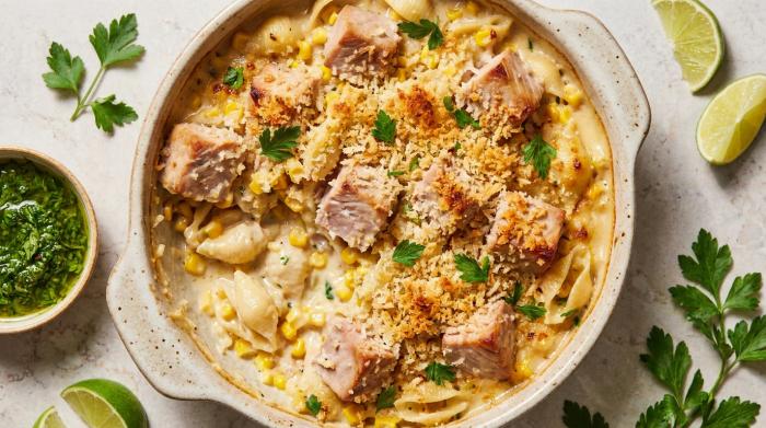 A scoop of creamy tuna pasta bake with a golden breadcrumb crust.