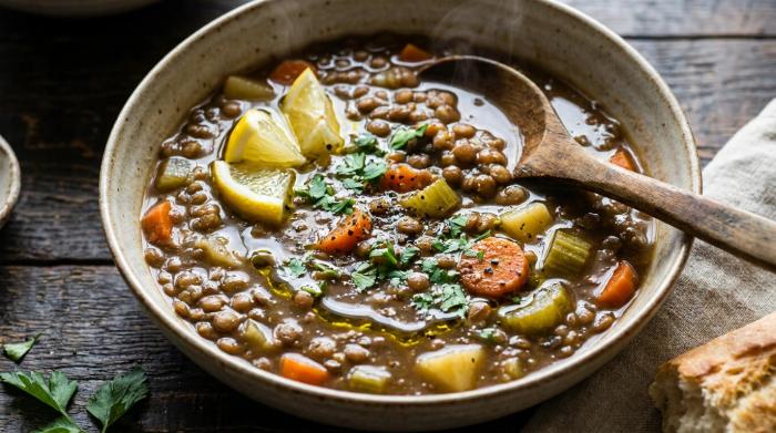 A bowl of warm lentil soup served with crusty bread.