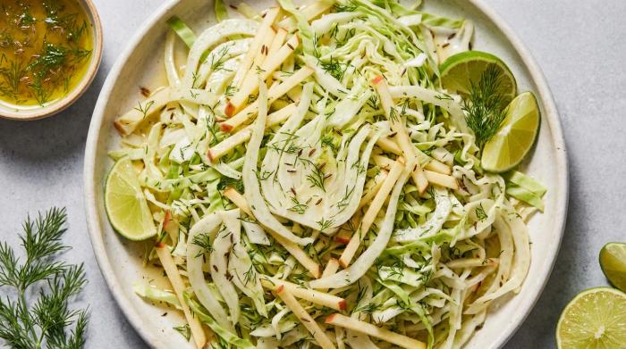 A bright and crunchy shredded cabbage, fennel, and apple slaw in a serving bowl.