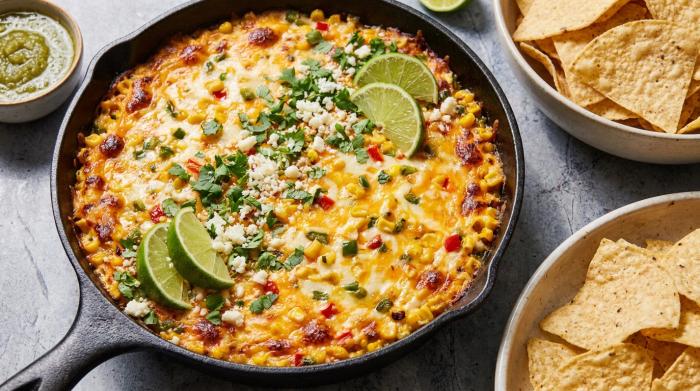 A corn chip holding a generous scoop of hot corn dip