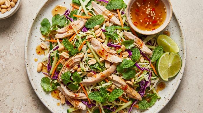 A colorful bowl of Vietnamese chicken salad topped with peanuts.